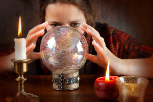 Young fortune teller in a red scarf working with her crystal ball